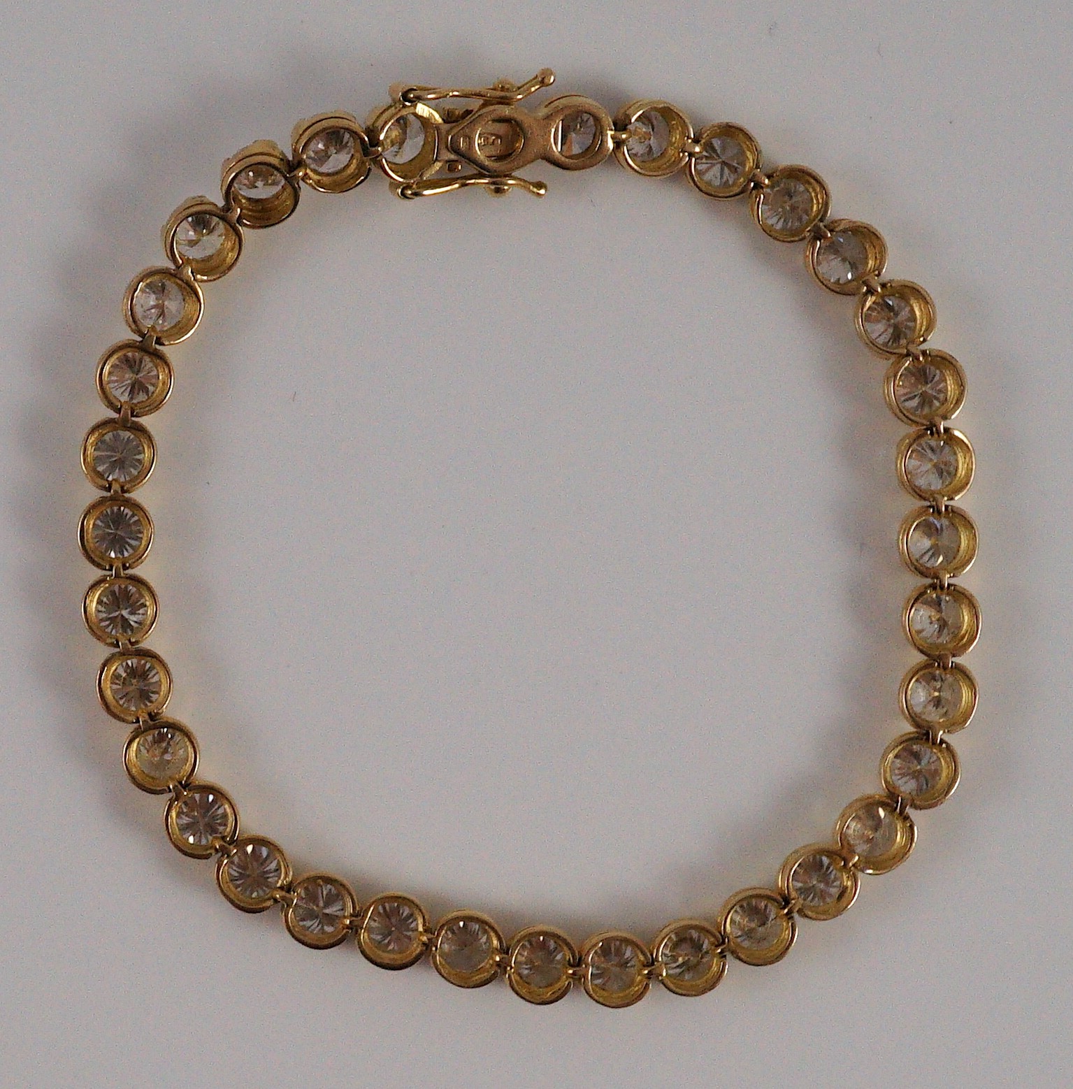 A modern 18k gold and round brilliant cut diamond set line bracelet